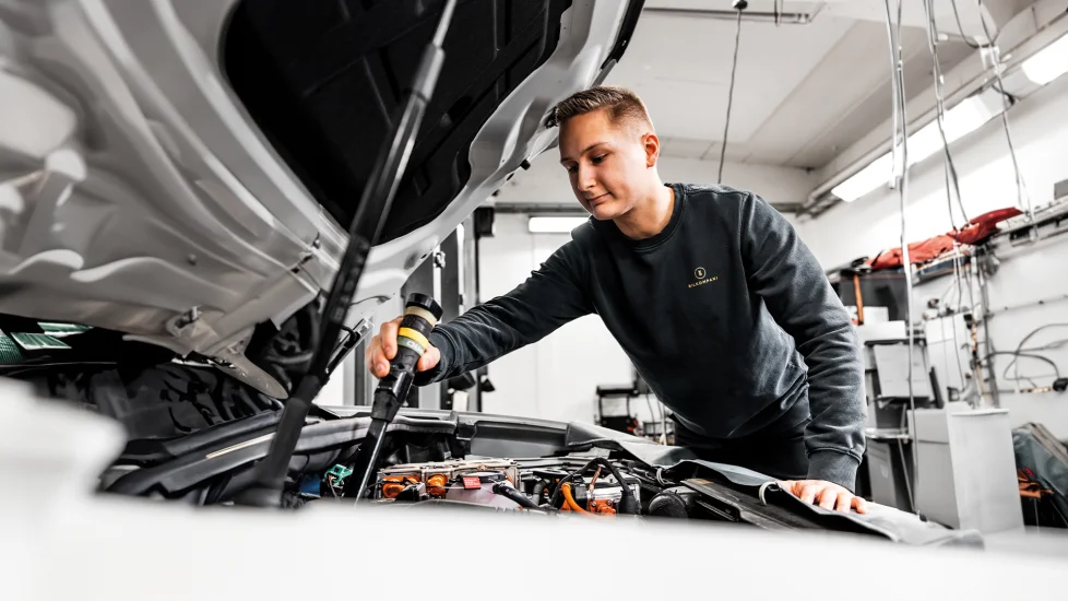 Mekaniker undersöker bil i motorrum på Bilkompani